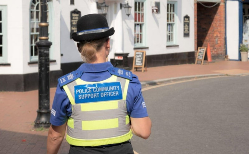 image of the back of a female police community support officer walking down a local street